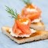 Crostini de ricota aromatizado com pesto, rúcula e salmão defumado