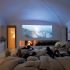 Um quarto exclusivo para você e seus amigos relaxarem em frente de uma lareira e de uma tela de projeção de 50 polegadas