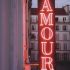 Sob o letreiro luminoso do Hotel Amour