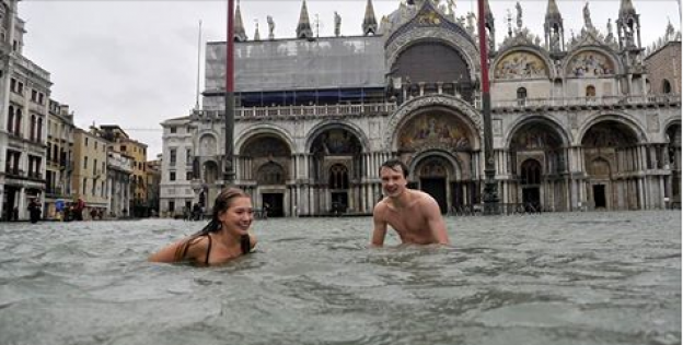 Turistas nadam em canal de Veneza